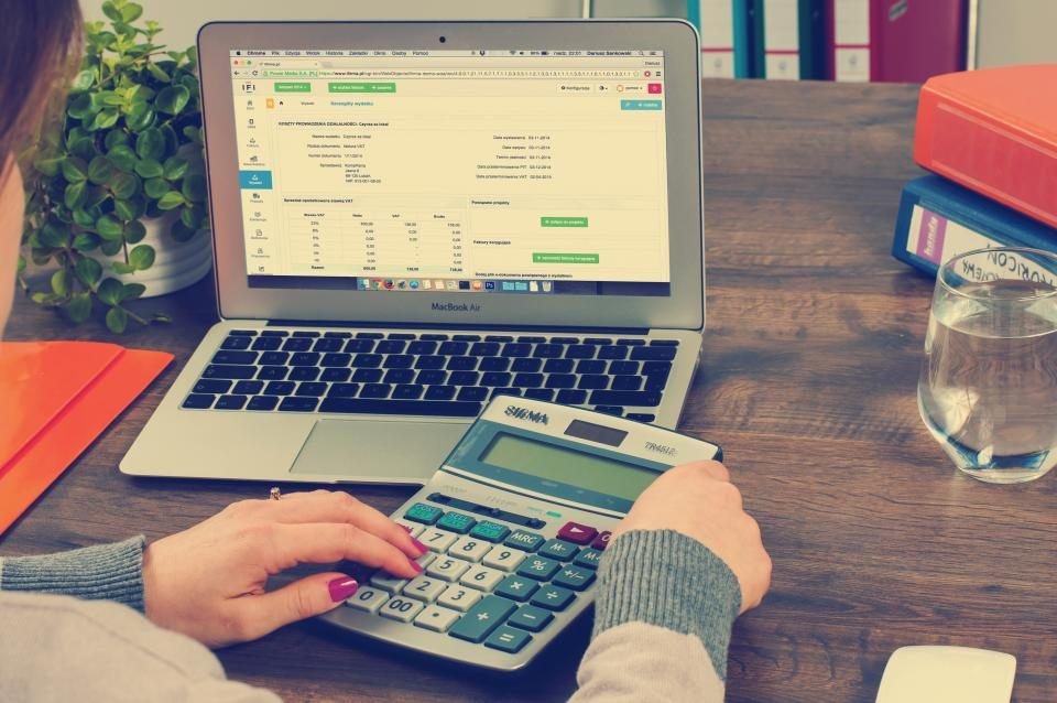 Accounting work with calculator and laptop